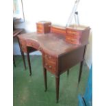 An Edwardian inlaid serpentine writing desk with brass gallery and four drawers to top and five