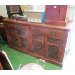 A large oak sideboard two drawers and four panelled cupboards with carved detail