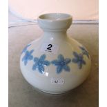 A Lladro vase blue flowers on a white ground