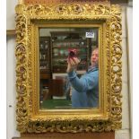 A giltwood framed mirror with pierced scroll leaf design frame