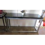 A pair of modern chrome and glass console tables