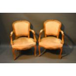 A Pair of French Fauteuils each with an upholstered back and seat with scroll arms raised upon