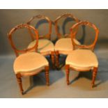 A Set of Four Victorian Walnut Balloon Back Side Chairs, each with a carved back above a stuff