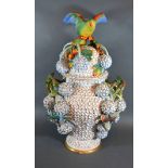 A German Porcelain Large Snowball Covered Vase with foliate encrusted decoration and bird