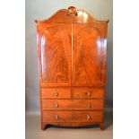 A William IV Mahogany Press Cupboard, the shaped moulded cornice above two arched doors enclosing