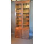 A Victorian Oak Bookcase, the moulded cornice above two glazed doors enclosing shelves, the lower