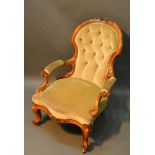 A Victorian Walnut Drawing Room Armchair, the carved and button upholstered back above a