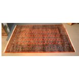 A Bokhara Woollen Rug with four rows of guls upon a red ground within multiple borders, 153 x 241
