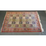 A North West Persian Silk Rug with an all over design upon a red, blue and cream ground within