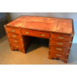 A Campaign Style Twin Pedestal Desk, the tooled leather inset top above nine drawers with sunken