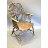 An Early 19th Century Elm Wheel And Stick Back Windsor Armchair with a panel seat raised upon turned