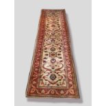 A North West Persian Style Woollen Runner with an all over design upon a cream, red and blue