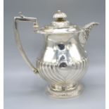 A George III Silver Coffee Pot of half lobed form with reeded handle London 1817, maker's mark IP,