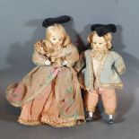 A pair of Victorian small dolls in the form of a lady and gentleman in period dress