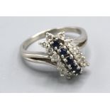 A Platinum Diamond And Sapphire Ring set with five sapphires surrounded by diamonds within a pierced