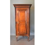 A 19th Century Oak Standing Corner Cabinet, the moulded top above a panelled door enclosing shaped