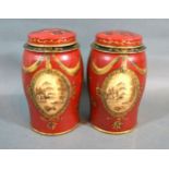 A Pair Of Tole Ware Small Canisters with gilded decoration upon a red ground 18 cms tall