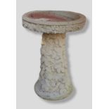 A Cast Concrete Birdbath decorated with leaves 71 cms tall