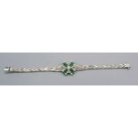 An 18ct White Gold Diamond And Emerald Set Bracelet with a central diamond surrounded by four