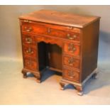 A George III Mahogany Kneehole Desk, the moulded top above a brushing slide and seven drawers with