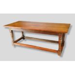 An Oak Refectory Style Dining Table, the plank top above a plain frieze raised upon four turned