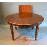 An Edwardian Mahogany Wind Out Extending Dining Table, the moulded top above a plain frieze raised