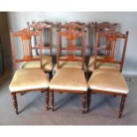 A Set Of Six Edwardian Walnut Dining Chairs, with carved splat backs and stuff over seats raised