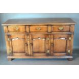 A Green Oak George III Style Dresser Base with three drawers above three panelled doors flanked by
