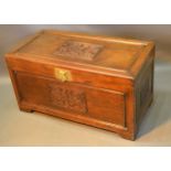 An Oriental Hardwood Chest, the carved hinged top above a similar front with brass escutcheon,