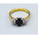 An 18ct. Yellow Gold Sapphire And Diamond Set Ring with central oval sapphire flanked by two