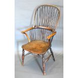 An Early 19th Century Elm Windsor Armchair, the stick back above a panel seat with turned legs and