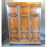 An Oak Triple Wardrobe In 18th Century Style with three moulded doors raised upon low bun feet 152