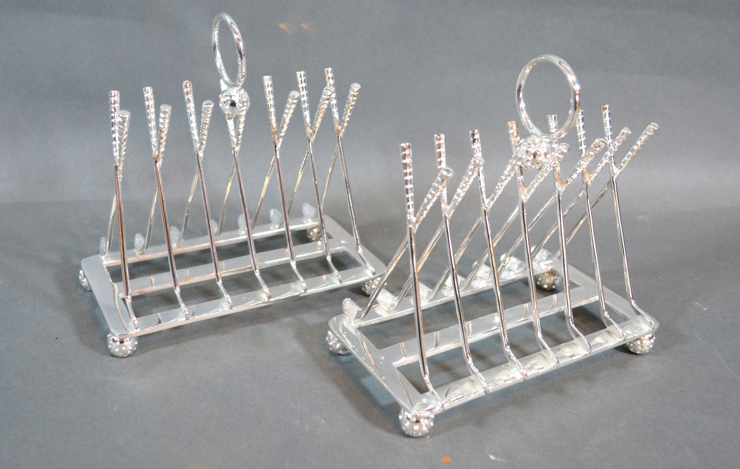 A Pair Of Silver Plated Six Division Toast Racks in the form of golf clubs, the feet in the form