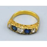 A Yellow Metal Sapphire And Diamond Band Ring set with two sapphire and three diamonds within a
