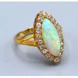 A Yellow Metal Dress Ring set with an opal surrounded by diamonds marquise set 5.2 gms. ring size L