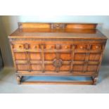 A 20th Century Oak Sideboard with a low galleried back above three drawers and three moulded doors