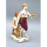 A Continental Figurine Of A Female With Artists Palette And Easel 23 cms tall