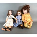 A Heubach Koppelsdorf German Bisque Headed Doll No. 3021 with composition body together with two