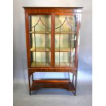 An Edwardian Mahogany Display Cabinet, the moulded cornice above two astragal glazed doors enclosing