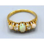 An 18ct. Gold Opal And Diamond Ring set with three opals and two diamonds within a pierced setting