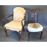 A Queen Anne Style Armchair with an upholstered back and seat with shaped arms raised upon carved