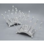 In The Style Of Christopher Dresser A Pair Of Silver Plated Six Division Toast Racks 22 cms long