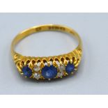 An 18ct. Yellow Gold Sapphire And Diamond Band Ring set three sapphire and four diamonds within a