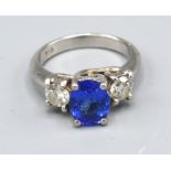 A Platinum Tanzanite And Diamond Ring with an oval cut tanzanite approximately 2.0 ct flanked by two