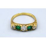 An 18ct. Gold Emerald And Diamond Ring set with two emeralds and three diamonds claw set 3.6 gms.
