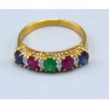 An 18ct Gold Multi Gem Set Band Ring set with sapphire, ruby, emerald and diamonds 2.4 gms. ring