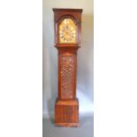 An Oak Long Case Clock, the arched hood with turned pilasters above a carved door raised upon low