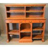 A Victorian Oak Bookcase, the moulded cornice above various open shelves and central drawers, 157