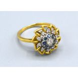An 18ct Yellow Gold Diamond And Sapphire Cluster Ring set central diamond and surrounded by