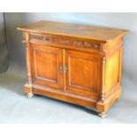 A 19th Century French Side Cabinet with a carved frieze drawer above two panelled doors flanked by